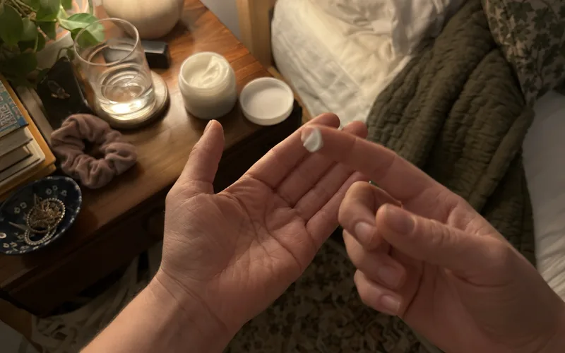 A pea-size amount of retinol cream on a fingertip at night